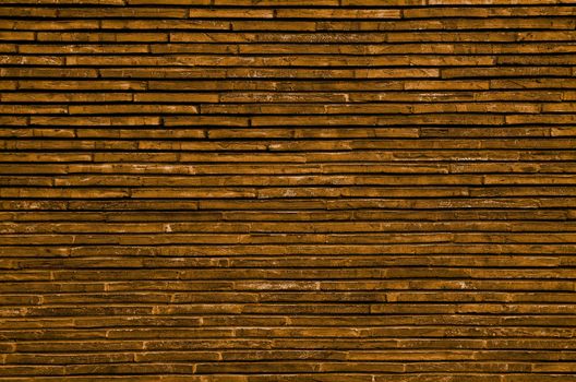 Background of Orange and Sand Colored Plank Stone Exterior Wall closeup