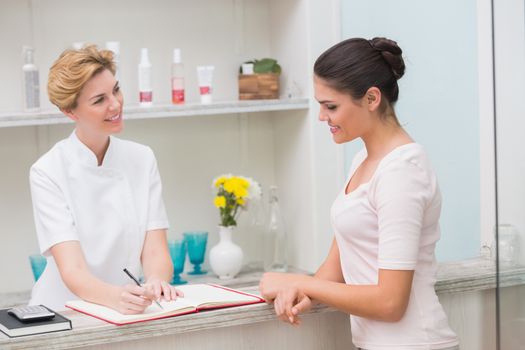 Pretty beautician talking with client at the beauty salon