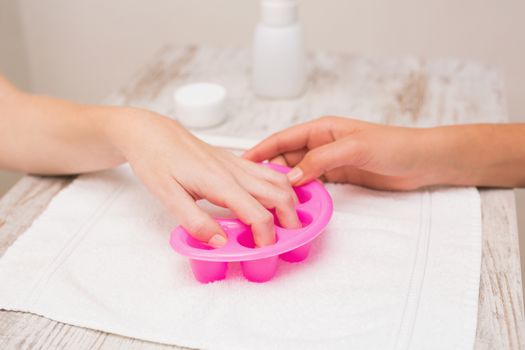 Woman soaking her nails in nail bowls at the beauty salon