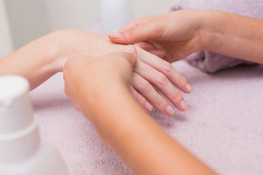 Woman getting a hand massage at the beauty salon