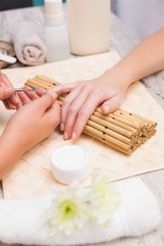 Nail technician giving customer a manicure at the beauty salon