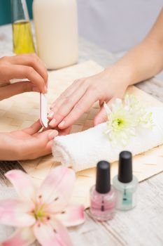 Nail technician giving customer a manicure at the beauty salon