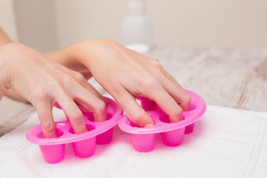 Woman soaking her nails in nail bowls at the beauty salon