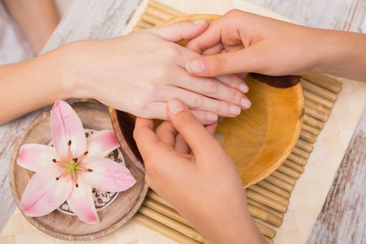 Nail technician giving customer a manicure at the beauty salon