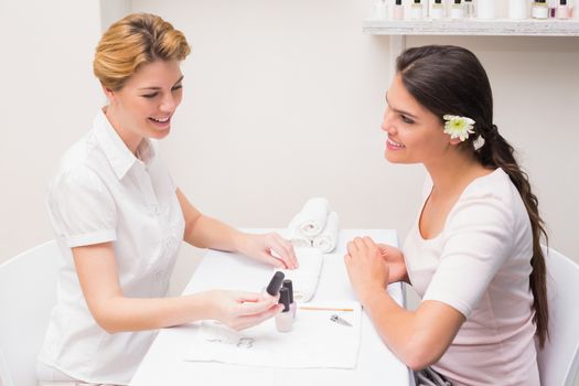 Nail technician giving customer a manicure at the beauty salon