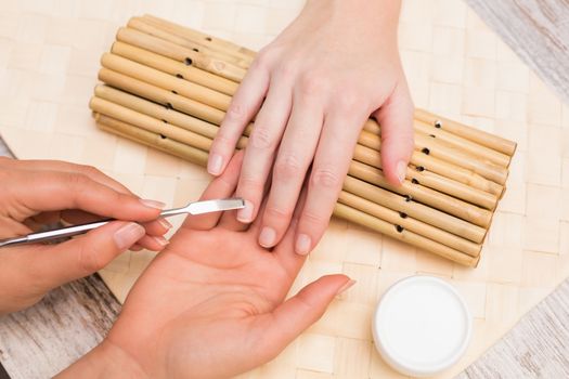 Nail technician giving customer a manicure at the beauty salon