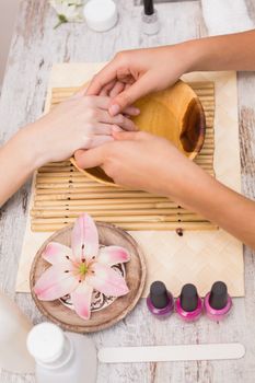 Nail technician giving customer a manicure at the beauty salon