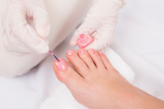 Woman getting her toenails painted at the beauty salon