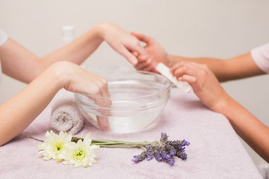 Nail technician giving customer a manicure at the beauty salon