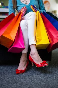 Woman holding many shopping bags in fashion boutique