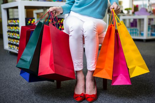 Woman with many shopping bags in fashion boutique