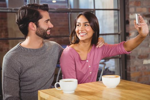 Cute couple taking selfie in a cafe