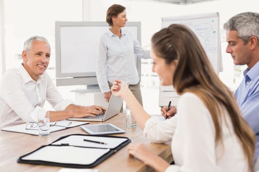 Smiling business people listening to presentation in the office