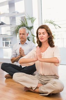 Peaceful casual business colleagues meditating in the office