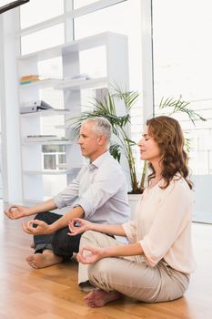 Peaceful casual business colleagues meditating in the office