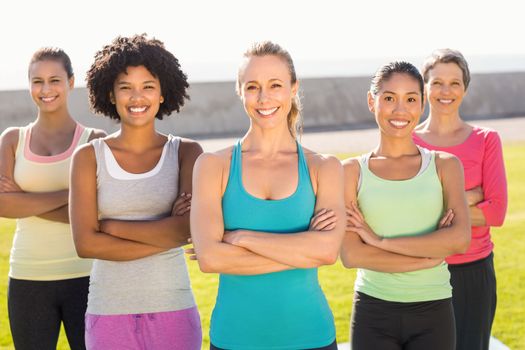 Portrait of smiling sporty women with arms crossed in parkland