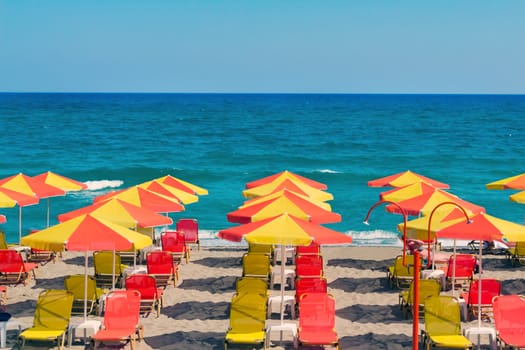 Umbrellas for sun protection and sun loungers on the deserted beach because of the storm .On waves of the sea.