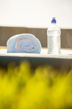Water bottle and towel on exercise mat at promenade
