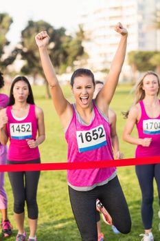 Portrait of cheering brunette winning breast cancer marathon in parkland