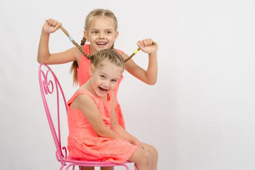 Two girls sisters in the same clothes having fun playing with each other