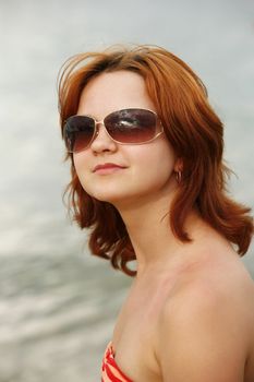 The girl with red hair in solar glasses