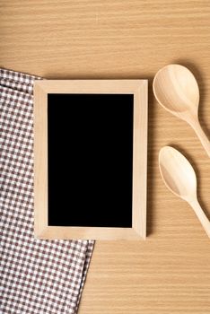 blackboard and wooden spoon on table