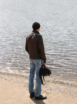 Handsome business man standing on the shore and gazing into the distance.