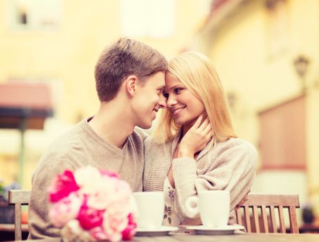 summer holidays, love, relationship and dating concept - romantic happy couple kissing in the cafe