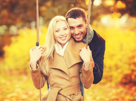 holidays, love, relationship and dating concept - romantic couple in the autumn park