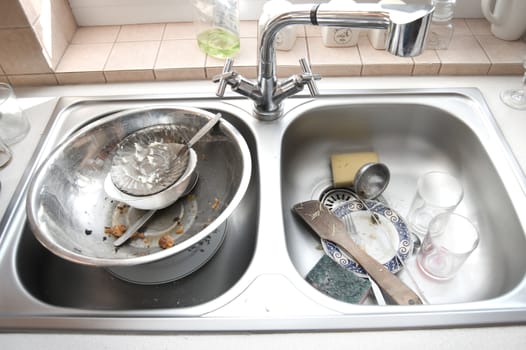 Kitchen conceptual image. Dirty sink with many dirty dishes.
