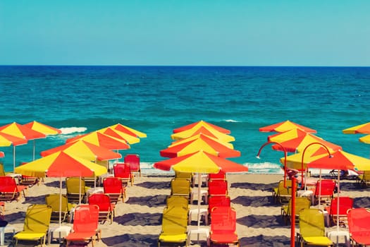 Umbrellas for sun protection and sun loungers on the deserted beach because of the storm .On waves of the sea.