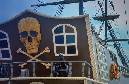 The photo shows a fragment of the stern of a yacht, with the image of a pirate symbols: skulls, crossbones, models of guns.