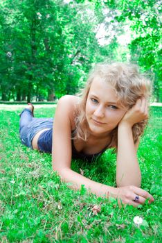 Young beautiful girl lies on the lawn.