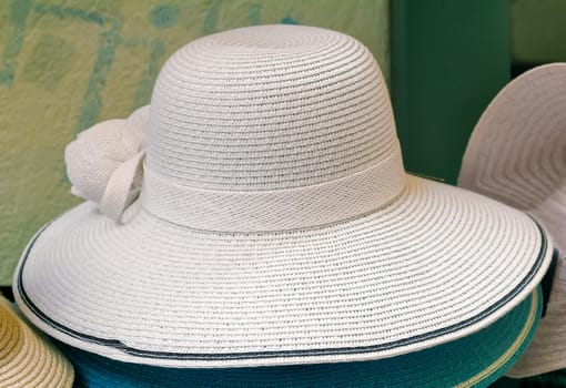 Women's summer hat with large brim, decorated with black ribbon, for protection from the sun.
