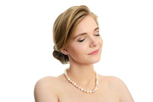 Beautiful female model with pearls on her neck. Portrait of young girl with closed eyes.