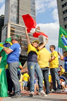 SAO PAULO, BRAZIL August 16 2015: An unidentified group of people with flags and yellow and green clothes in the protest against federal government corruption in Sao Paulo Brazil.