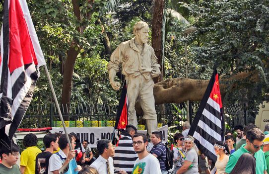 SAO PAULO, BRAZIL August 16, 2015: An unidentified group of people with flags in front of Bartolomeu Bueno da Silva statue in  the protest against federal government corruption in Sao Paulo Brazil.