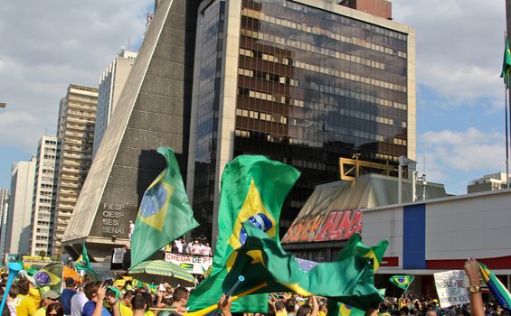 SAO PAULO, BRAZIL August 16 2015: An unidentified group of people with flags and yellow and green clothes in the protest against federal government corruption in Sao Paulo Brazil.