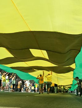 SAO PAULO, BRAZIL August 16, 2015: An unidentified group of people hold a big flag in the protest against federal government corruption in Sao Paulo Brazil. Protesters call for the impeachment of President Dilma Rousseff.