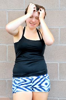 Female beauty expressions against a wall outside.