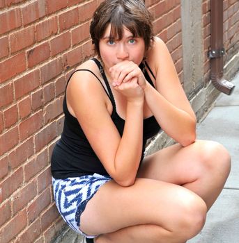 Female beauty expressions against a wall outside.