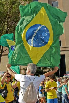 SAO PAULO, BRAZIL August 16, 2015: An unidentified man with a flag in the protest against federal government corruption in Sao Paulo Brazil.