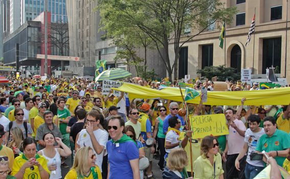 SAO PAULO, BRAZIL August 16 2015: An unidentified group of people with flags and yellow and green clothes in the protest against federal government corruption in Sao Paulo Brazil.