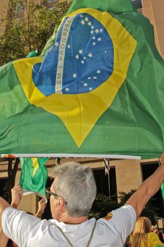 SAO PAULO, BRAZIL August 16, 2015: An unidentified man with a flag in the protest against federal government corruption in Sao Paulo Brazil.