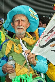 SAO PAULO, BRAZIL August 16, 2015: An unidentified man with yellow green and blue costume in the protest against federal government corruption in Sao Paulo Brazil. Protesters call for the impeachment of President Dilma Rousseff.