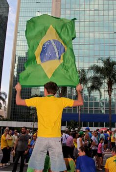 SAO PAULO, BRAZIL August 16, 2015: An unidentified man with a flag in the protest against federal government corruption in Sao Paulo Brazil.