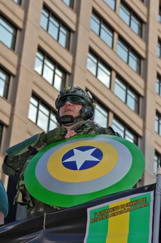 SAO PAULO, BRAZIL August 16, 2015: An unidentified man dressed as a super hero with colors yellow and green in the protest against federal government corruption in Sao Paulo Brazil.