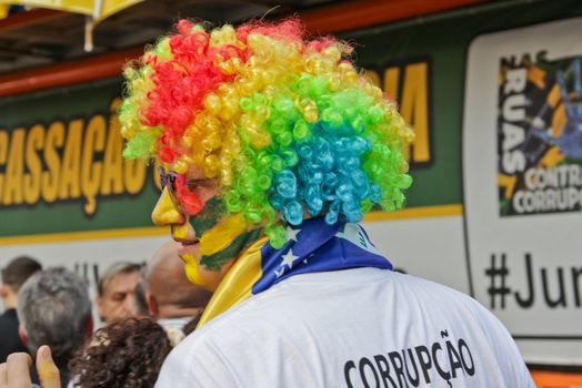 SAO PAULO, BRAZIL August 16, 2015: An unidentified man with yellow and green clown costume in the protest against federal government corruption in Sao Paulo Brazil.