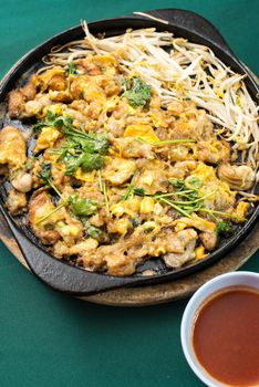 Thai food, fried mussel pancake in hot pan or Oysters on the hot pan
