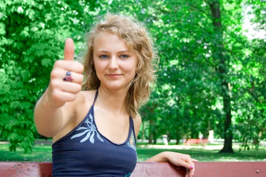 Young beautiful girl shows a thumbs-up gesture.